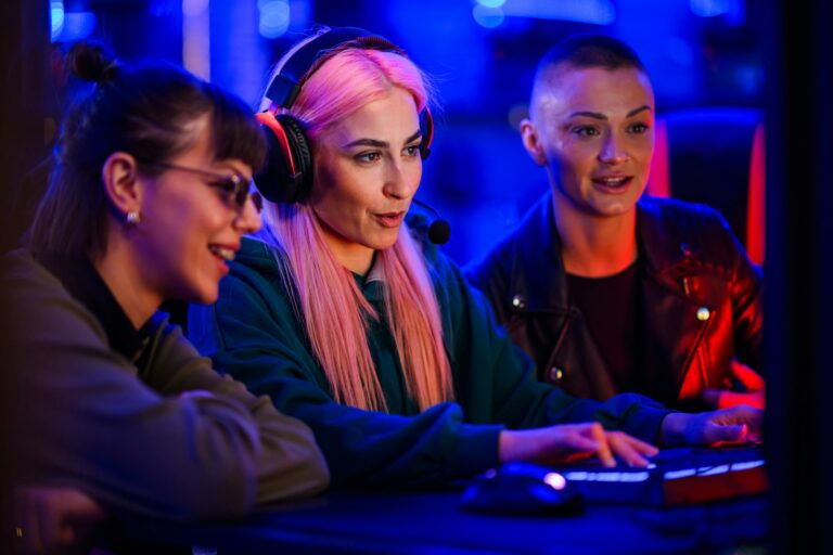 Woman gamer with pink hair sitting in a cyber club and playing a video game