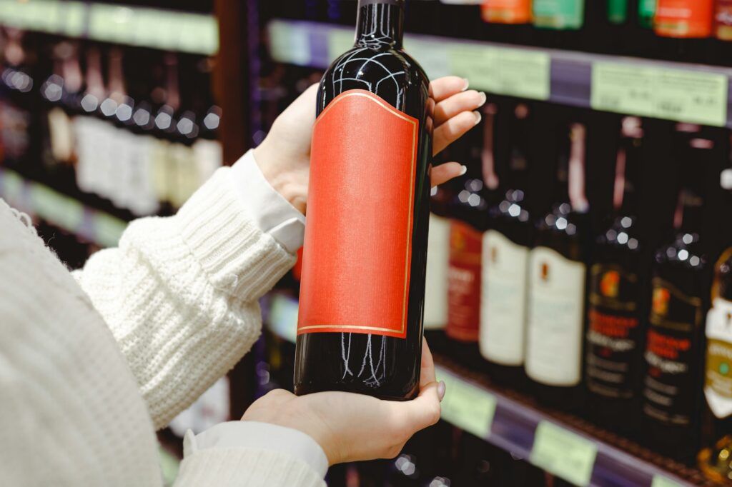 Woman holding Red wine bottle in supermarket