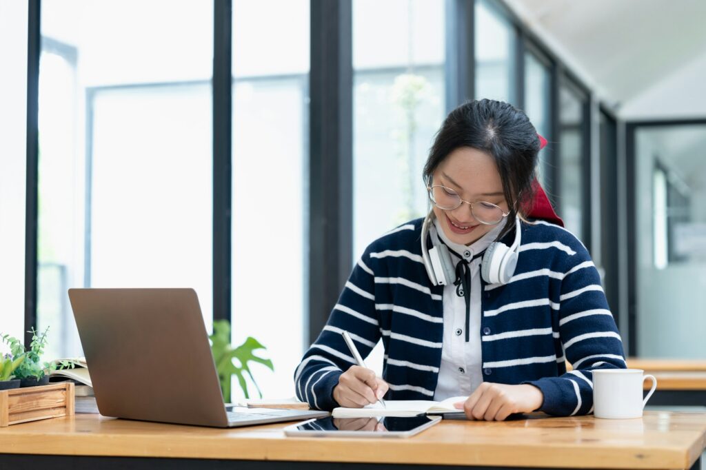 young woman enjoying self-directed learning with online educational tools. Bright student writing