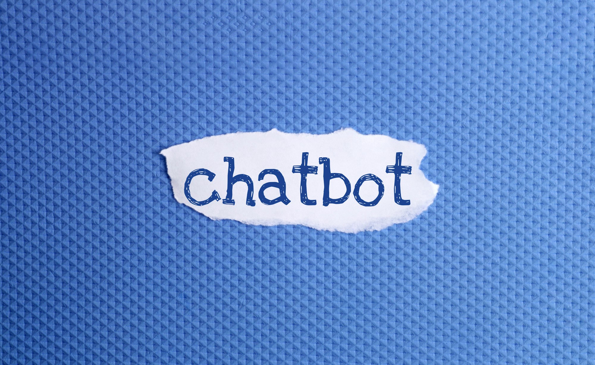 a torn paper written with inscription Chatbot on a blue background