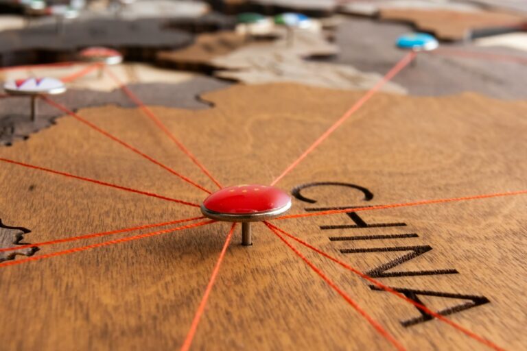 China flag on the pushpin and red threads on the wooden map