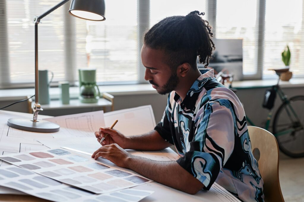 Creative Middle Eastern man working on floor plans