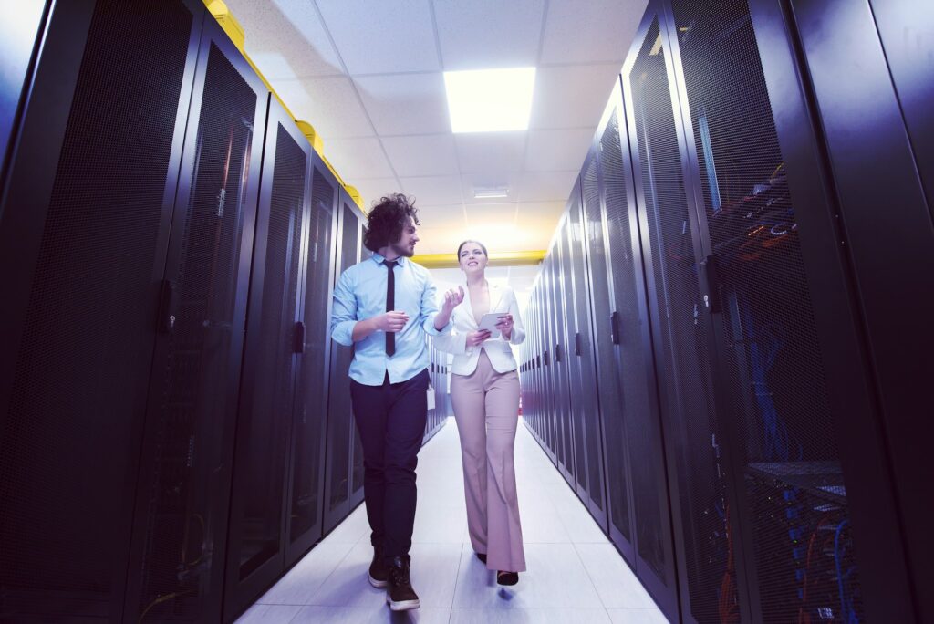 engineer showing working data center server room to female chief