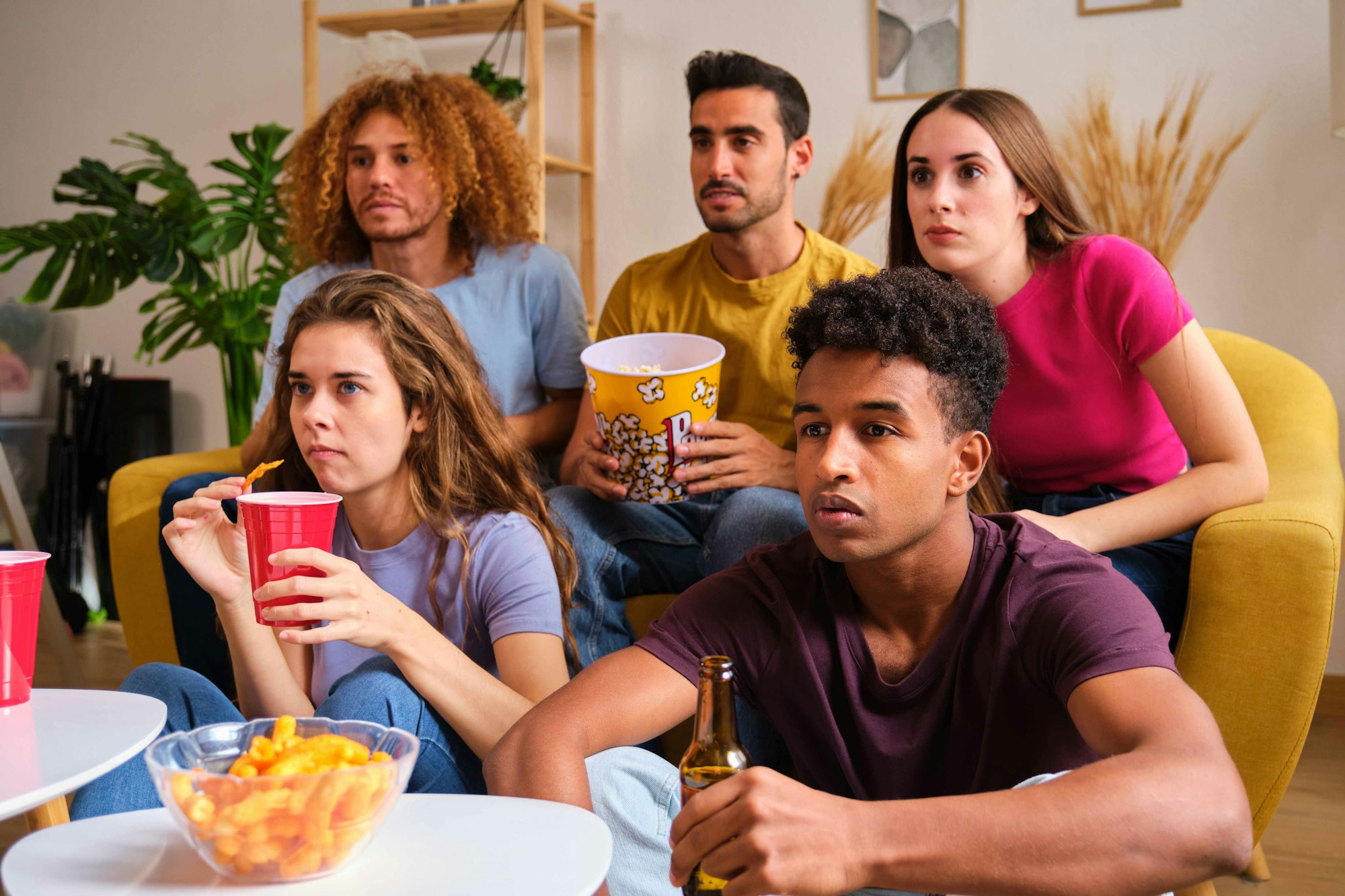 Group of friends watching a thriller stared intently.