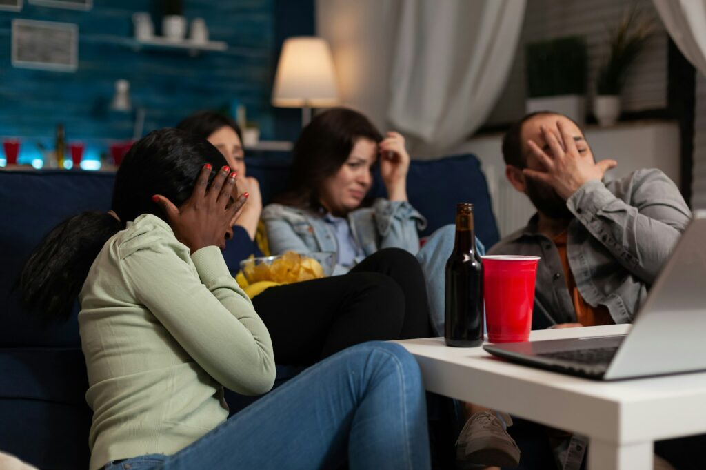 Group of multi-ethnic friends watching horror thriller movie on laptop computer