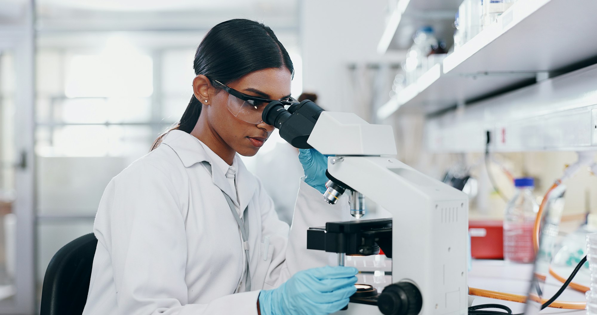 Medical, research and woman with microscope, healthcare and check experiment for cancer treatment.