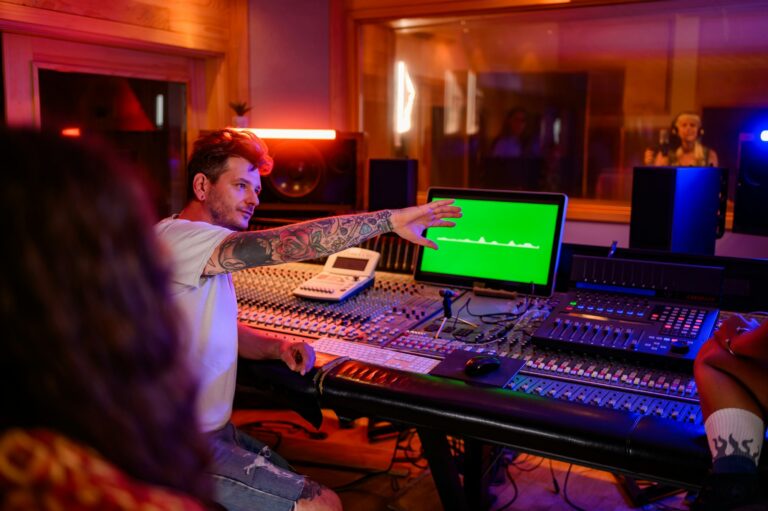 Music technician raised hand during recording of a vocal track in music studio.