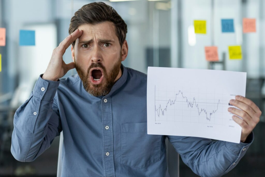 Shocked businessman reacting to stock market chart in office