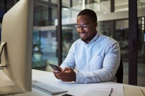 Social media phone, night work and businessman reading an email on smartphone while working in a da