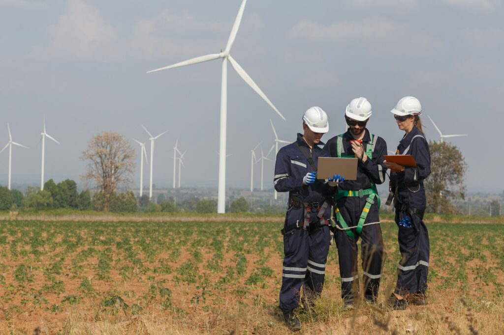 Team engineer wind turbine worker safety uniform survey discuss operational