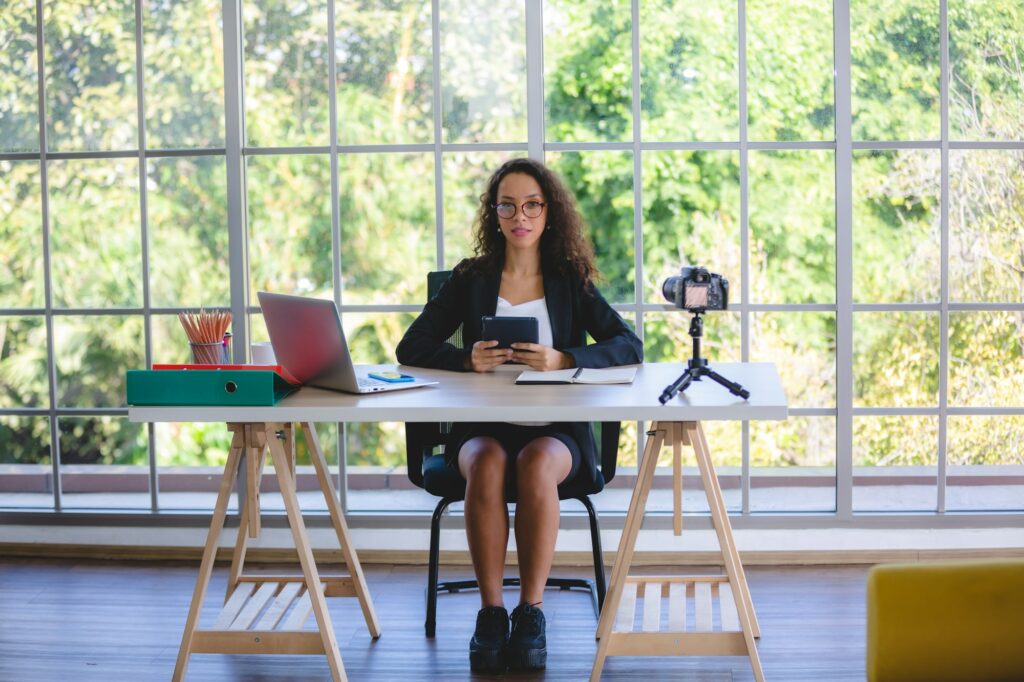 Young business woman and freelancer and social media influencer sitting on work desk