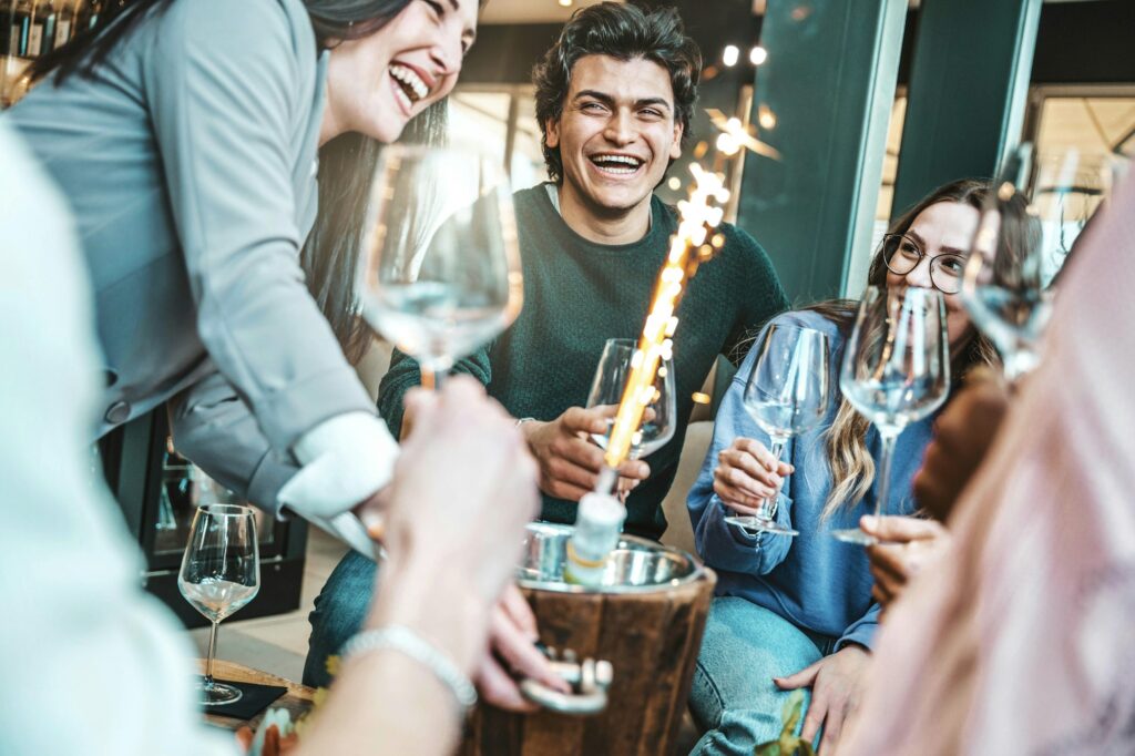 Young people celebrate party in fancy cocktail bar drinking champagne