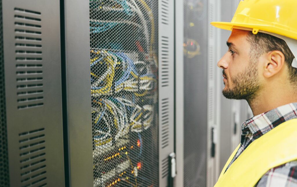 Young technician man working with inside big data center room - Focus on worker eye