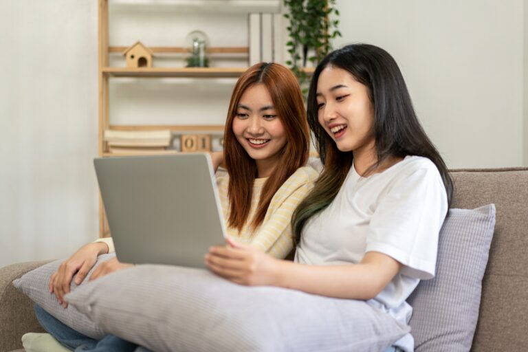 Young woman lesbian couple sitting to embracing and watching mov