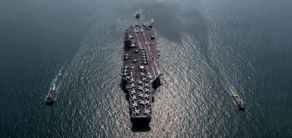 Aerial view military nuclear ship navy ship carrier full loading fighter jet aircraft.