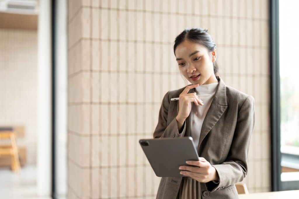 Confident Business Professional Analyzing Data on a Tablet in a Modern Office Environment