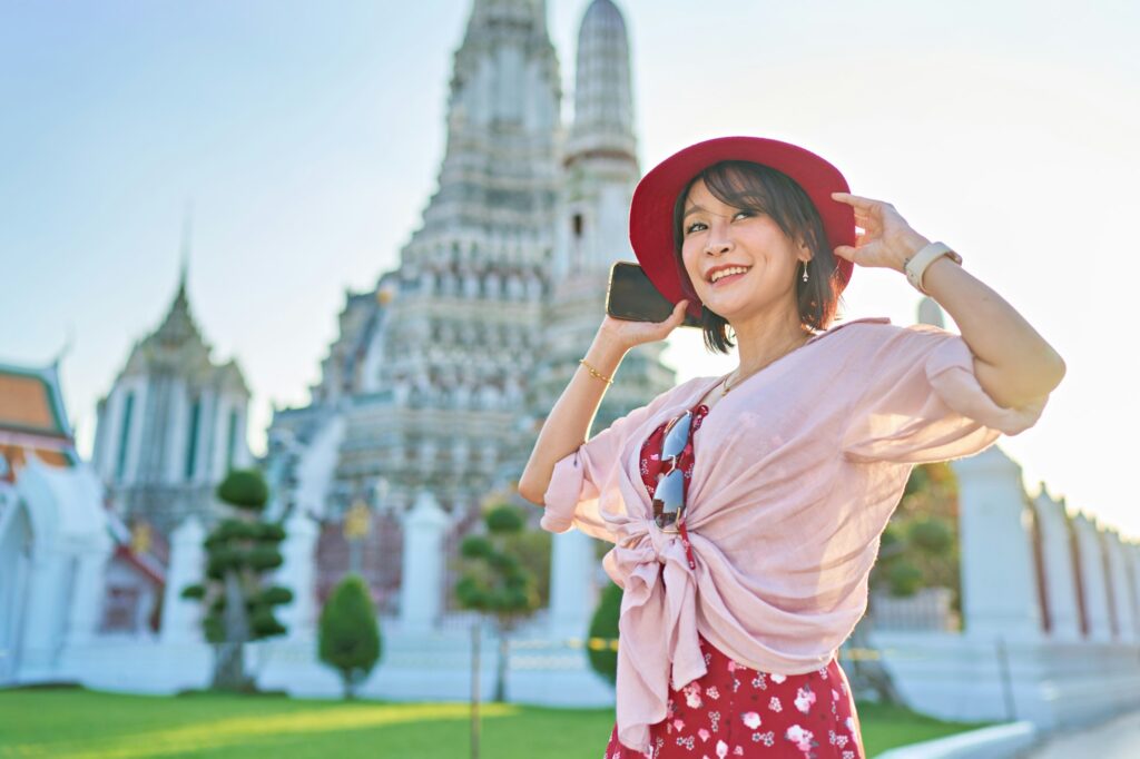 happy thai woman at war arun temple in background located in bangkok thailand