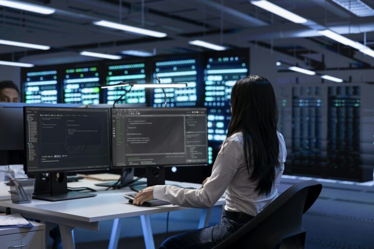 Programmer in data center checking equipment performance on computer