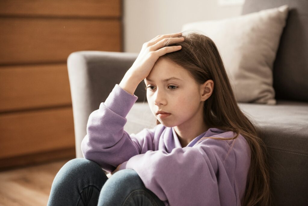 Sad child at home. Abuse. Depression girl indoors. Family problems, misunderstanding of parents,