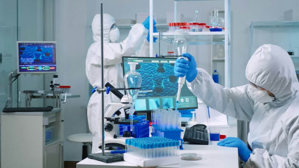 Scientist wearing coverall examining drug discovery with micropipette