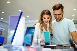 Shopping a new digital device. Happy couple buying a smartphone in store.