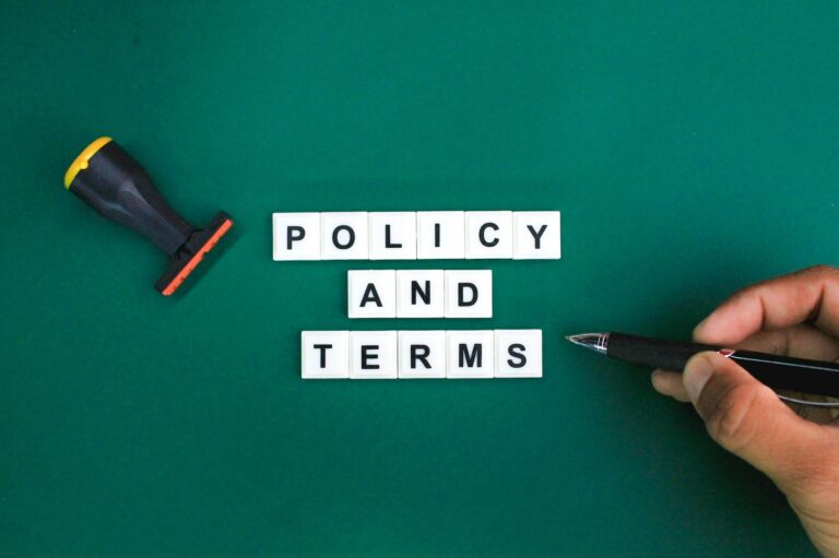 stamp and a hand holding a pen with the word policy and terms