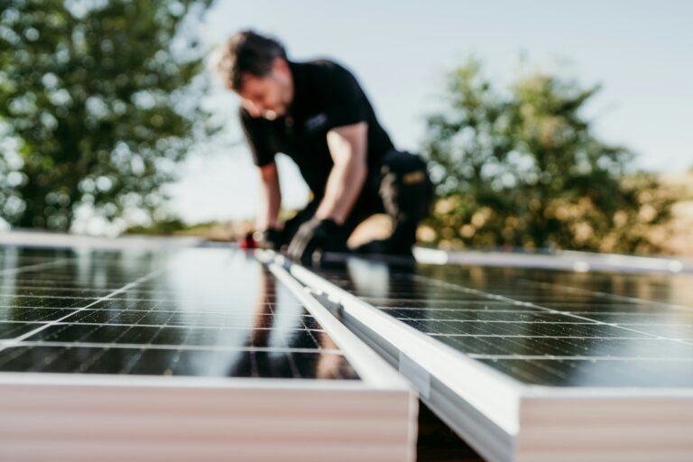 Technician assembling solar panels on house roof for self consumption energy. Renewable energies