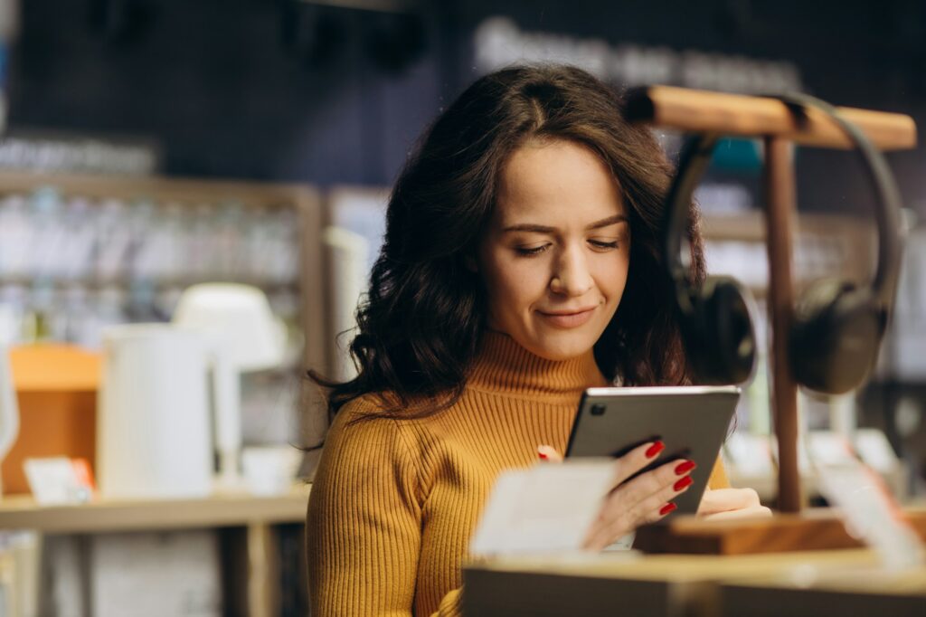 woman in an tech store chooses a tablet