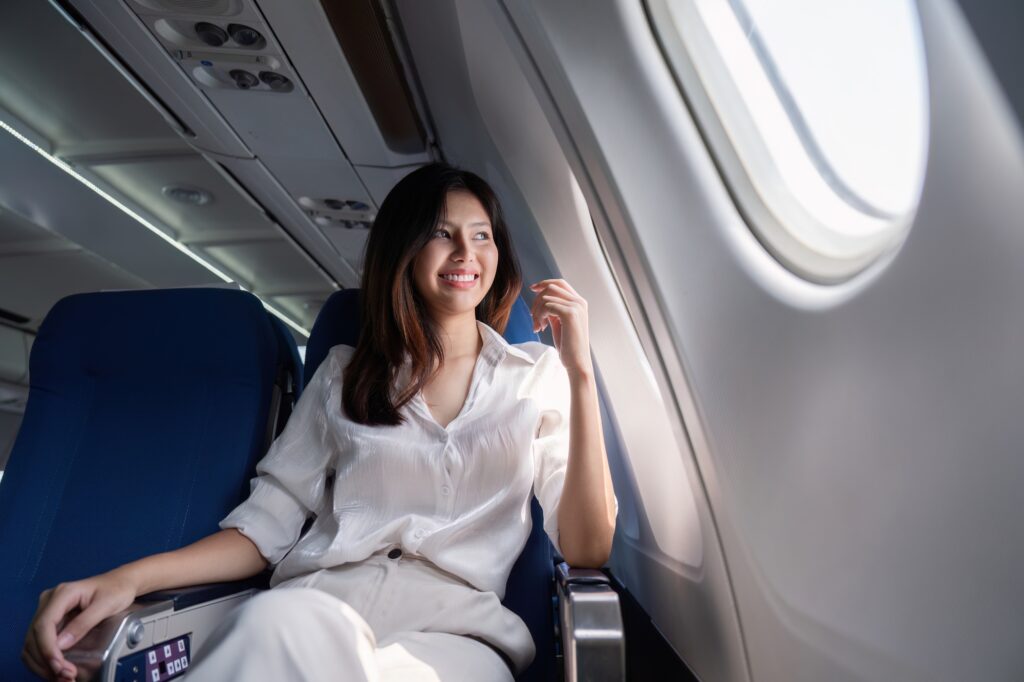 Businesswoman traveling on airplane seat. Concept of business travel and work