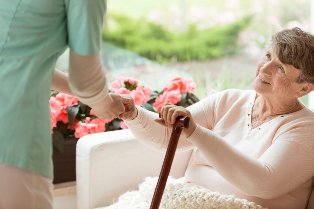 Doctor helping an elderly woman with Parkinson's disease get up