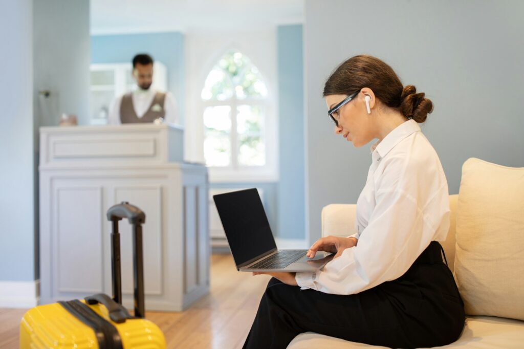 European Young Businesswoman Websurfing On Laptop in Hotel Lobby