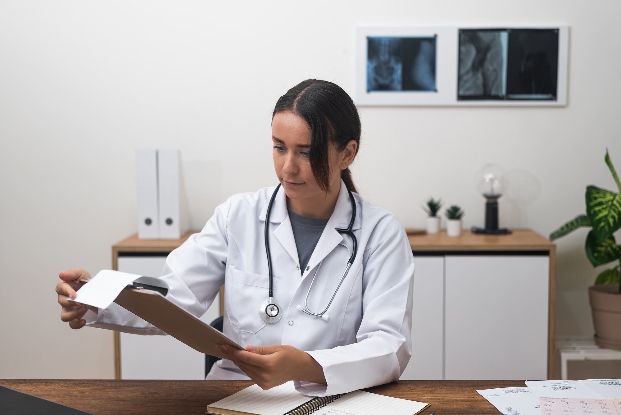 female doctor looks at patient test at her clinic desk, underscoring modern healthcare innovations.