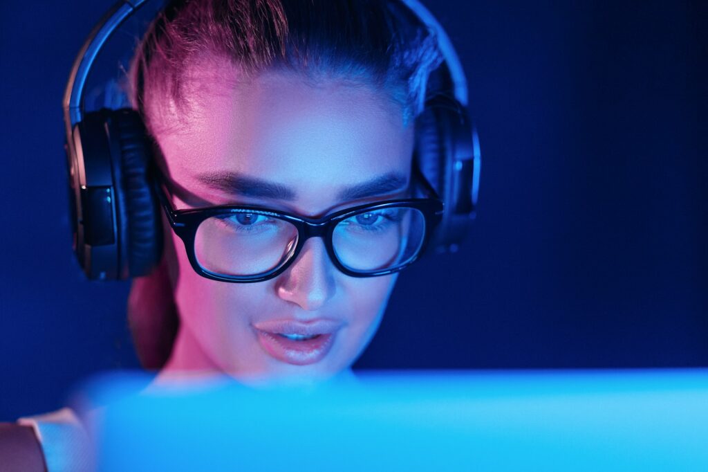 Female pro gamer playing video game, wearing headset