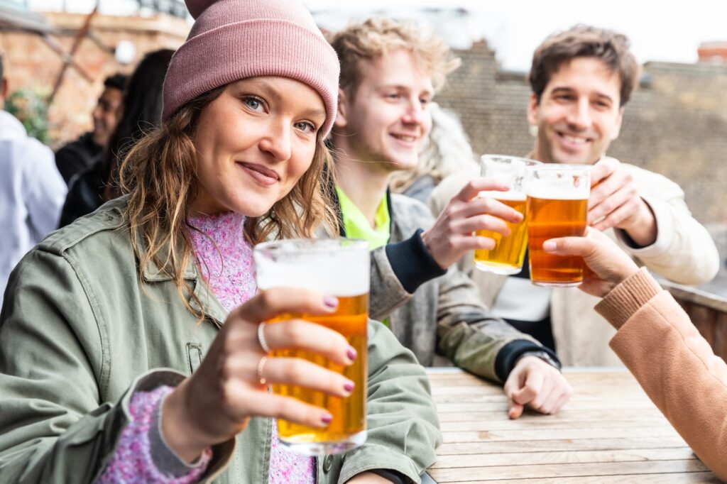 Friends drinking and toasting with beer at pub