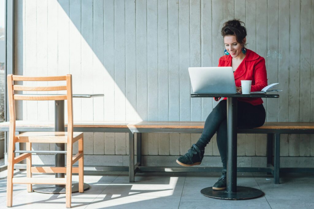 happy freelance businesswoman in a coffee shop working on her digital business, earning money online