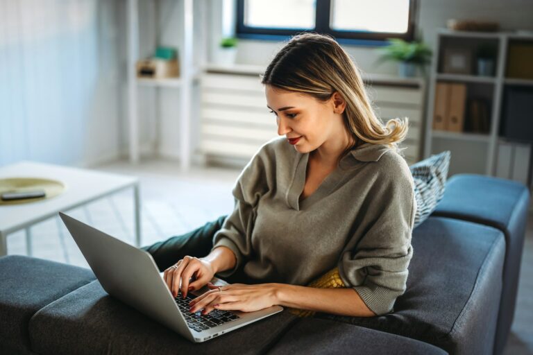 Home office. One smiling woman using laptop. Work, freelance, social media, technology concept.