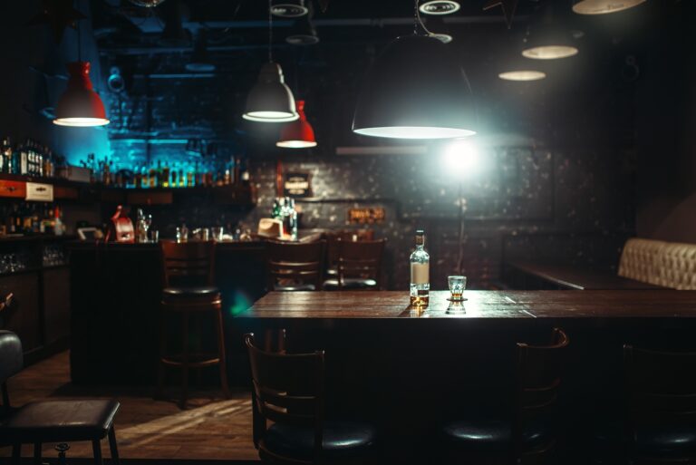 Pub, bottle of alcohol and glass on bar counter