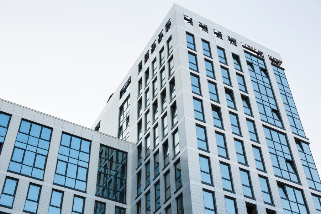 Transparent walls with small ajar windows reflecting bright blue sky