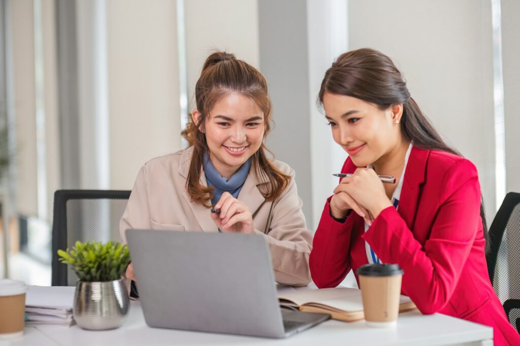 Two business women are discussing and exchanging knowledge on graphs and finance data.