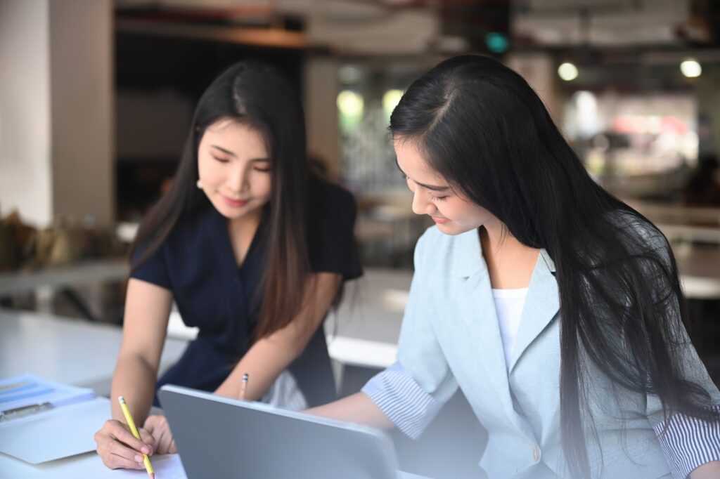 Two young woman working on the new design project in the modern coworking space.