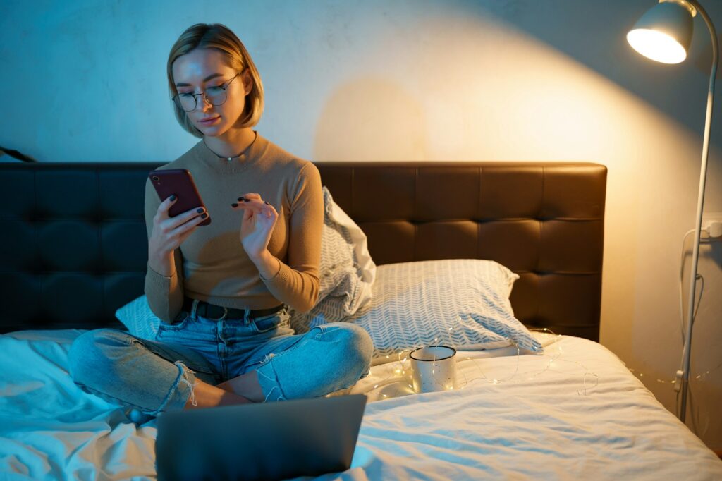 Woman in glasses checking social apps and working