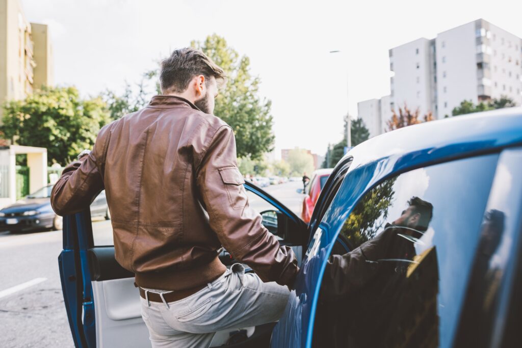 Young bearded man driving car