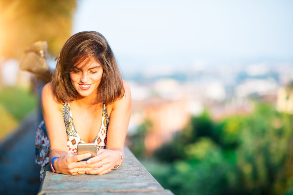 Young beautiful girl on a wall in a city