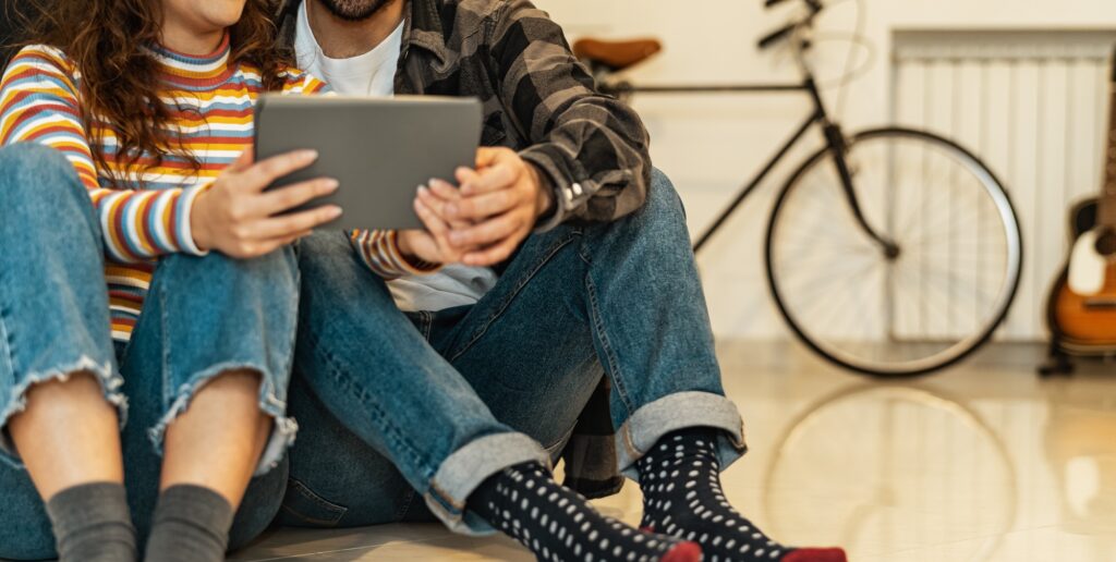 Young couple using tablet at home - Social people having fun with new trends technology devices