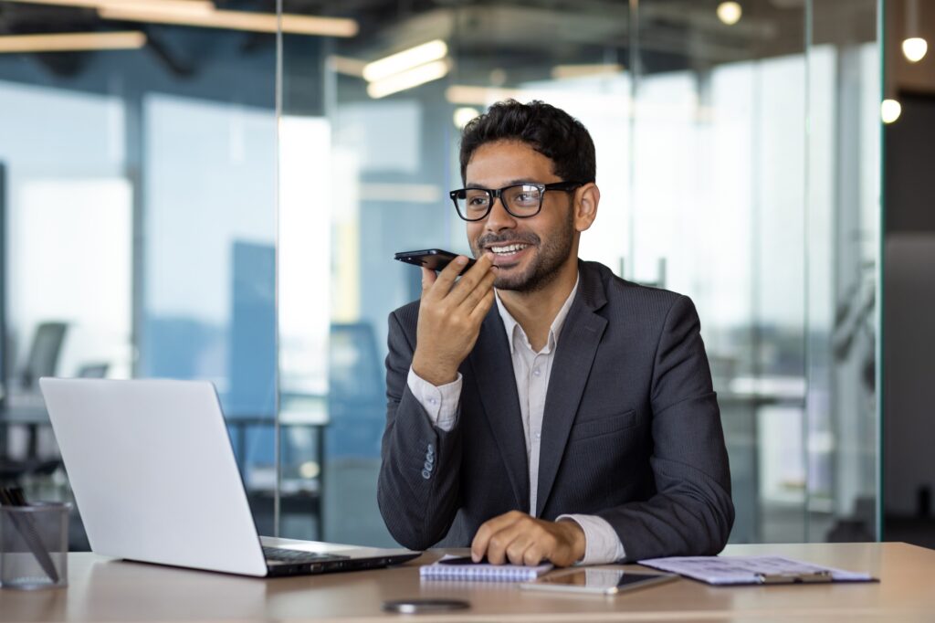 A man inside the office writes down the main message using an application on the phone, a smiling