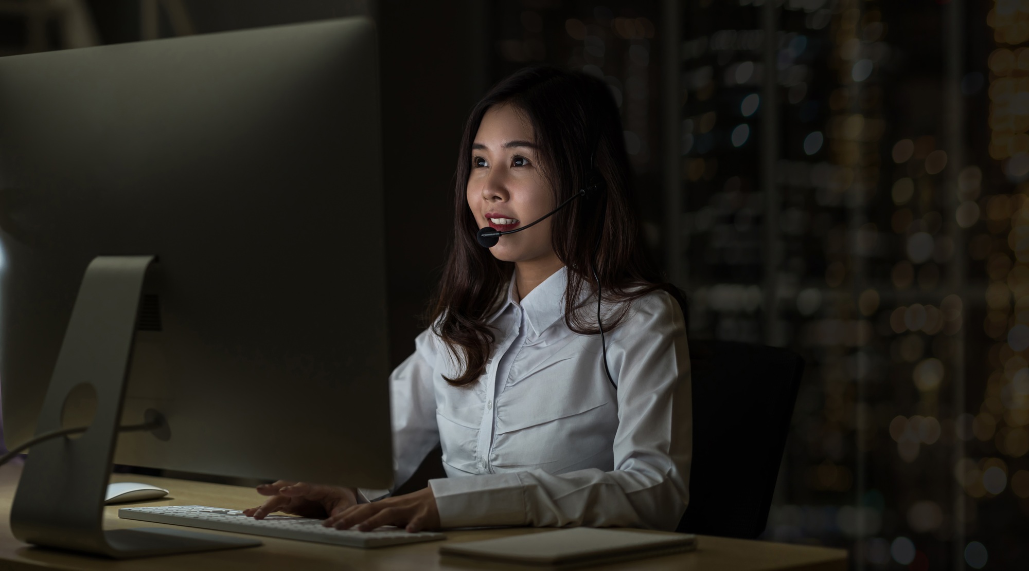 Asian Woman support desk working hard late in night shift at office