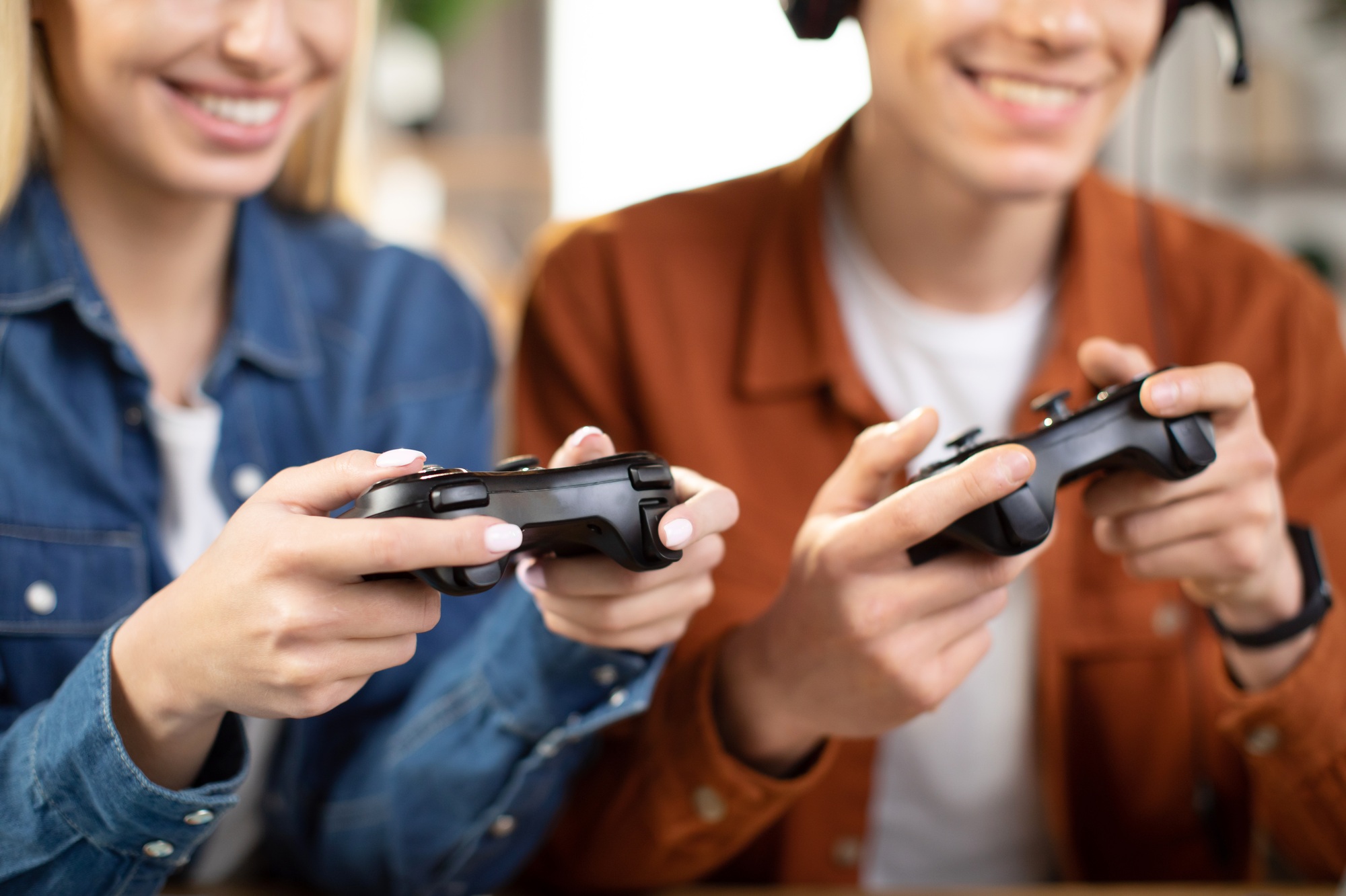 Caucasian family hands, holding joysticks and enjoying their free time playing new games at home