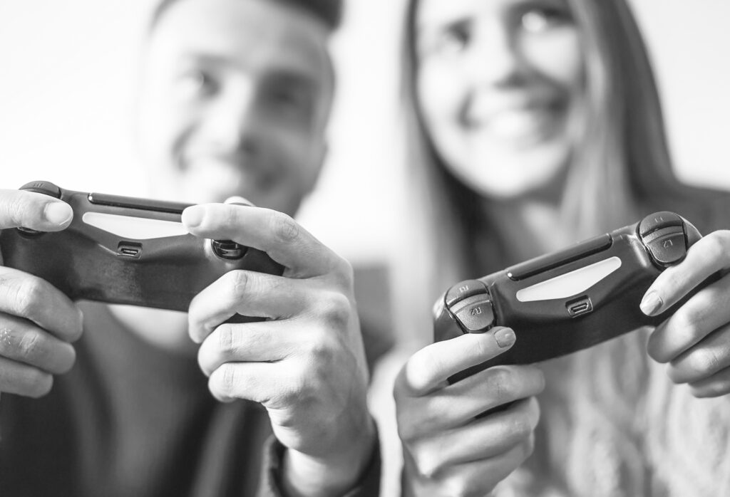 Excited couple playing video games at home