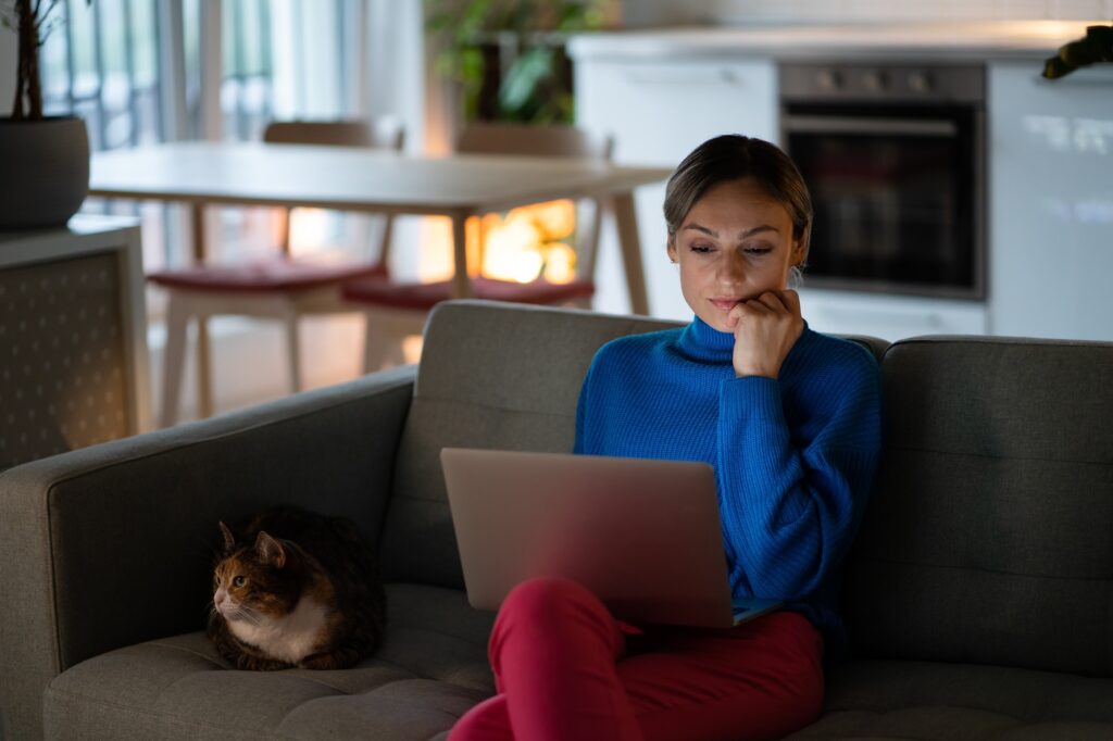 Focused businesswoman sitting on comfortable sofa works on important project for upgrading business