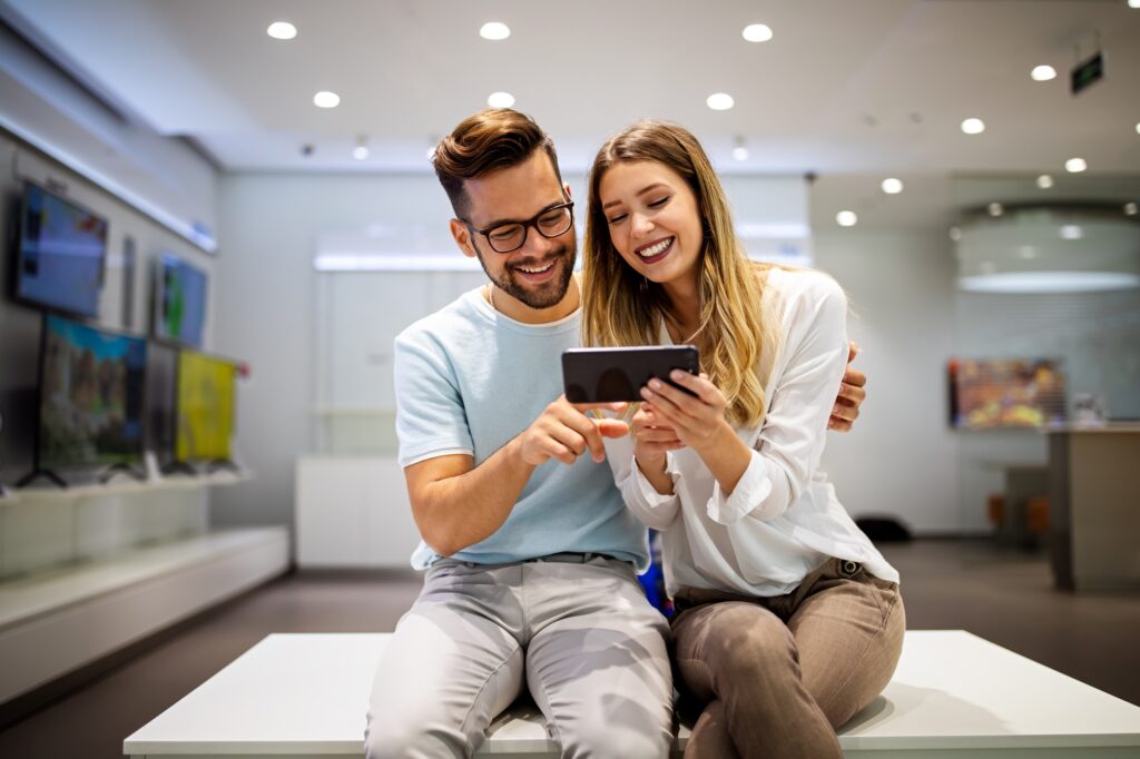 Happy couple enjoying social media content in a smart phone. Communication, connection concept.